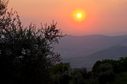 Vista al tramonto sulle colline a sud di Montalcino e sul Castello di Velona